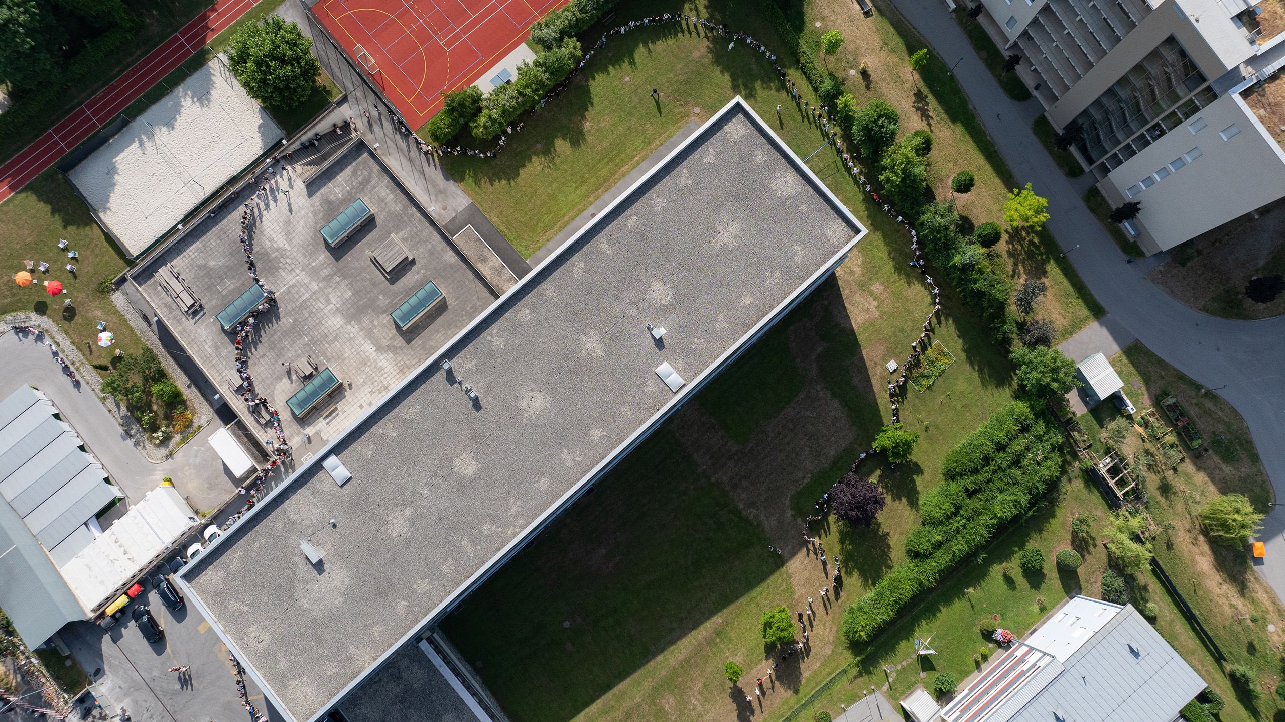 Drohnenaufnahme des BORG Dreierschützengasse, um das Schülerinnen und Schüler eine Menschenkette bilden.