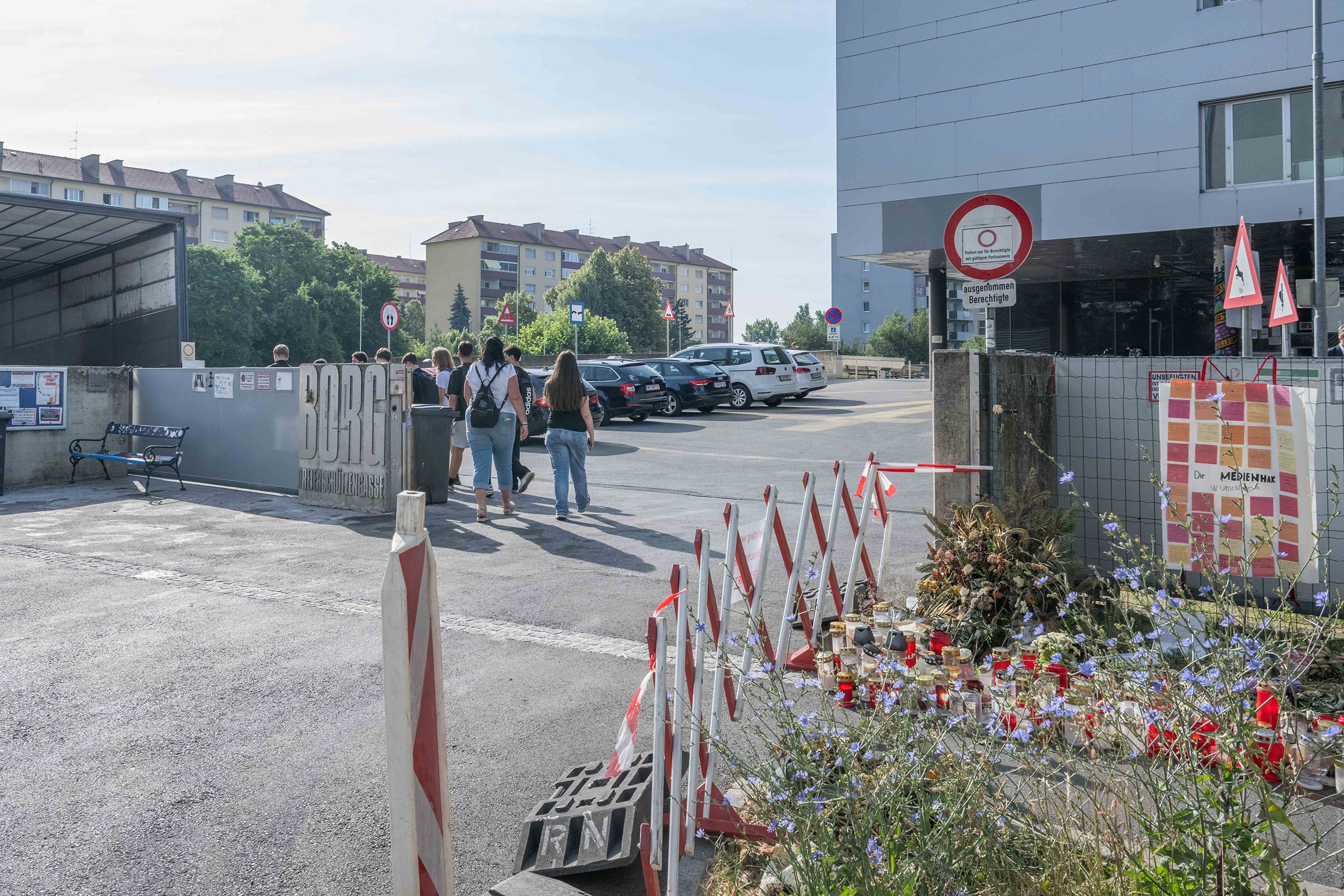 Eingangsbereich des Schulgeländes des BORG Dreierschützengasse, zu sehen sind Schülerinnen und Schüler sowie Grabkerzen.