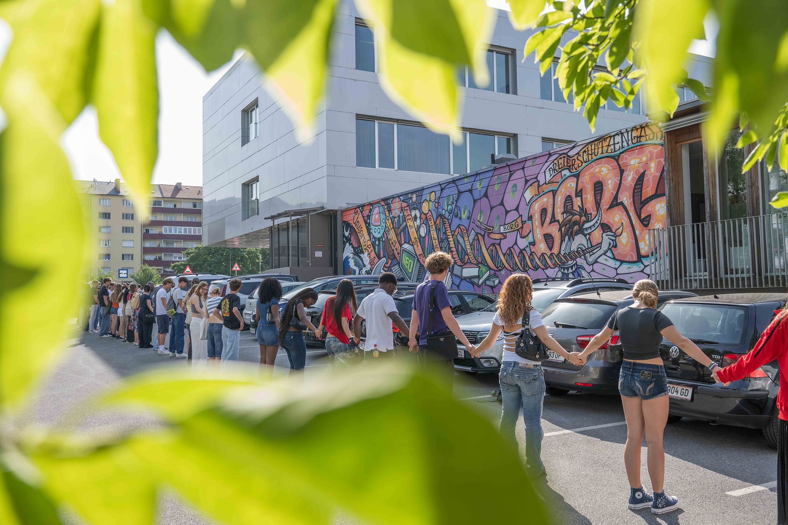 Schüler und Schülerinnen bilden eine Menschenkette vor dem BORG Dreischützengasse in Graz.