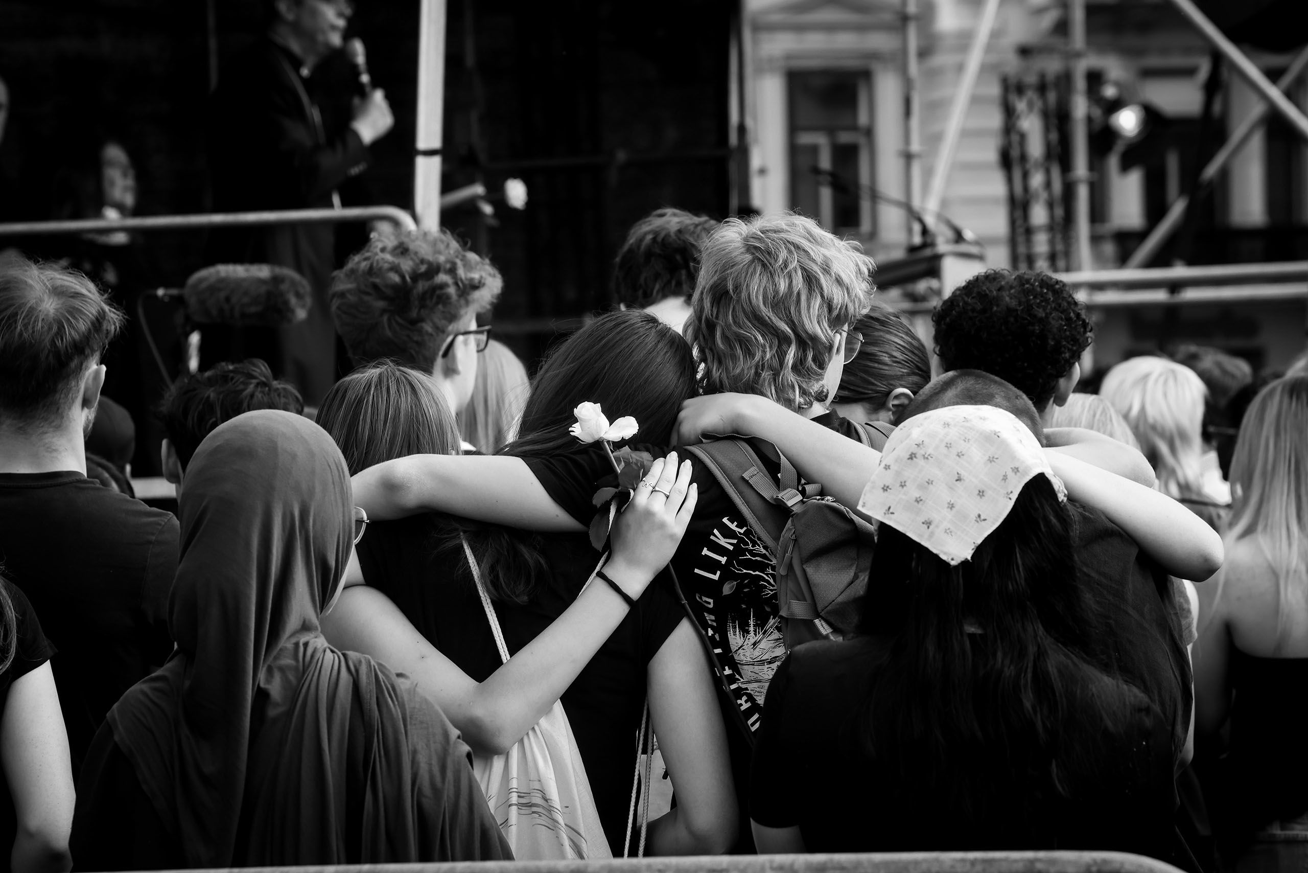Junge Frauen und Männer umarmen sich bei einer Gedenkveranstaltung in Graz.