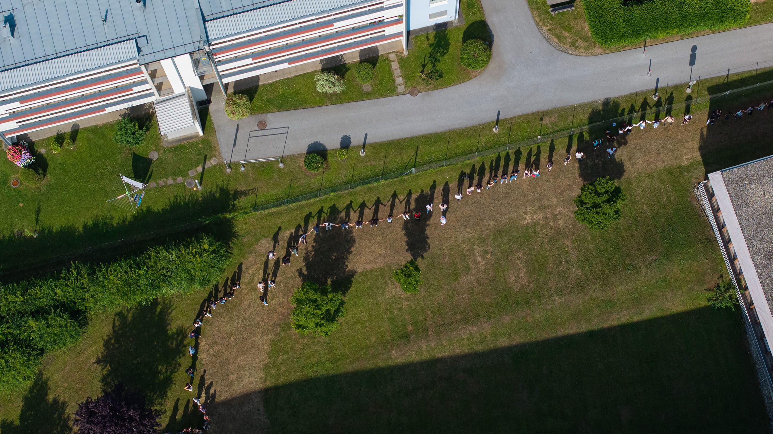 Drohnenaufnahme des BORG Dreierschützengasse, um das Schülerinnen und Schüler eine Menschenkette bilden.