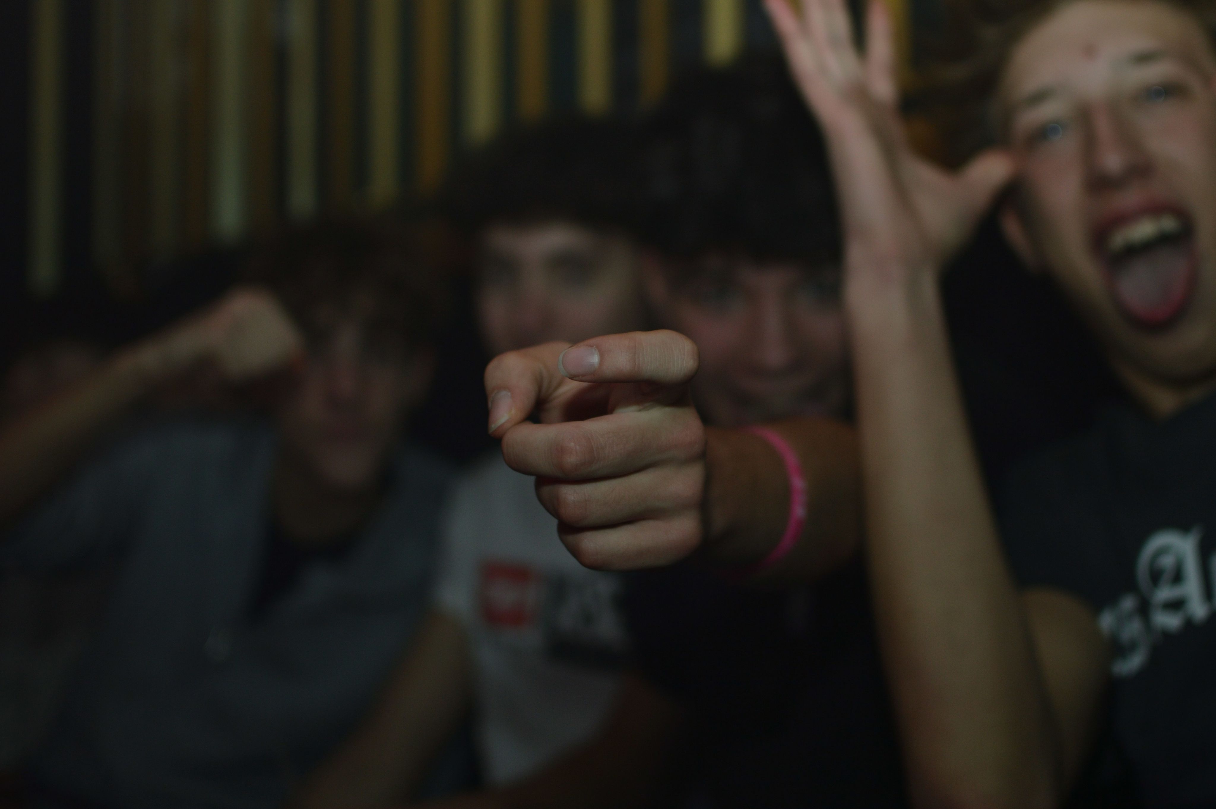 Junger Man zeigt in Richtung Kamera.