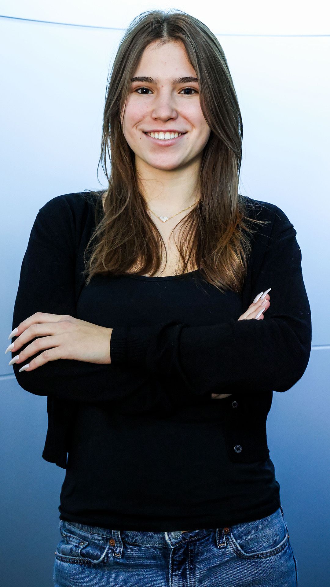 Die Schülerin trägt einen schwarzen Pullover und posiert für das Foto.